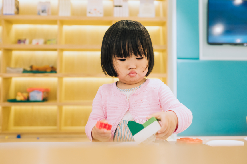 asian little girl playing with building blocks