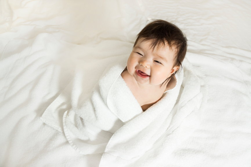 Happy baby girl wrapped in towels